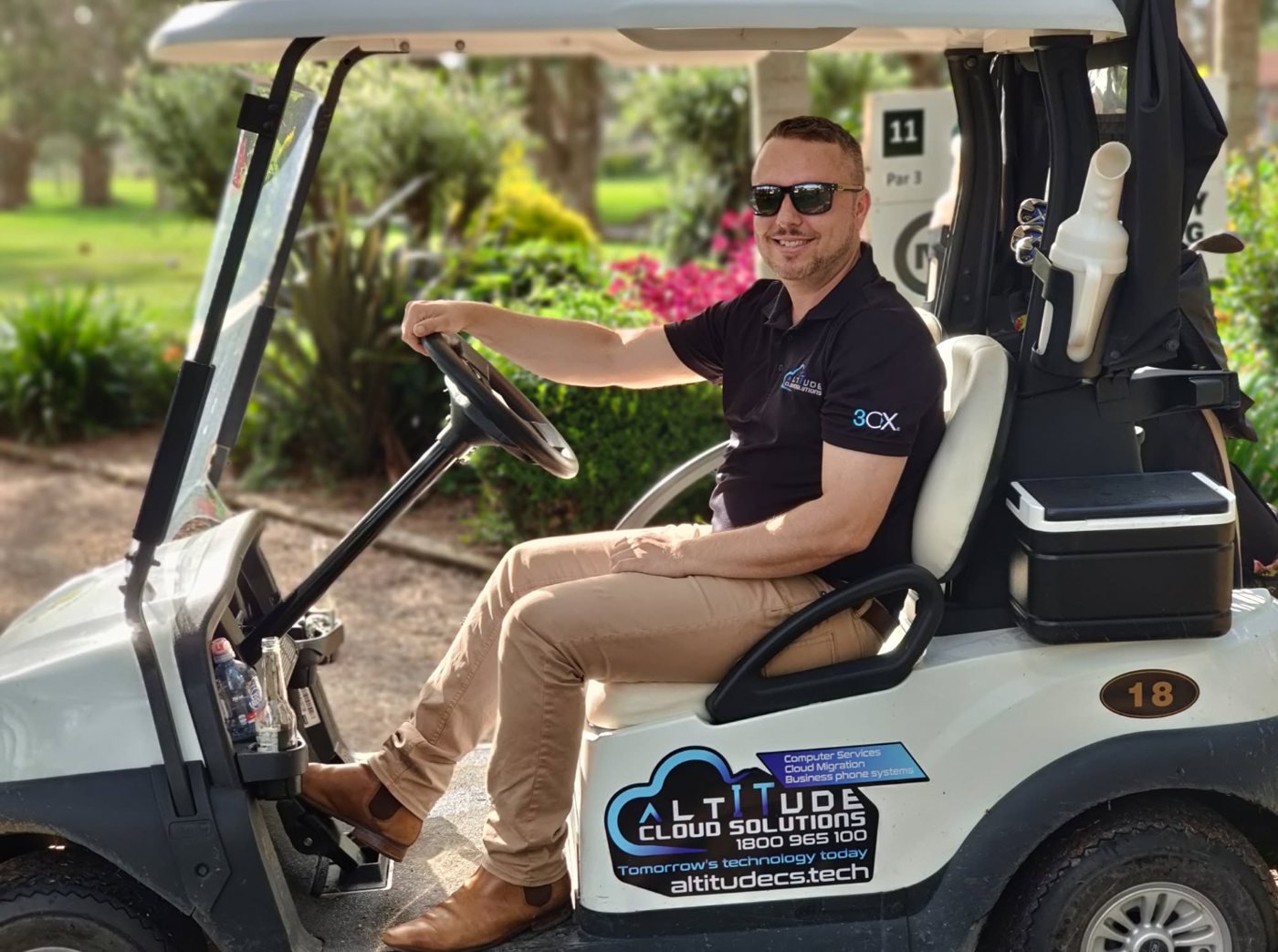 ACS team member at a local golf club in an Altitude Cloud Solutions branded cart